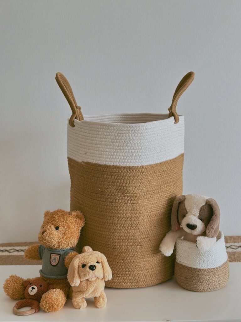 Handmade brown and white basket with teddy bear and plush dog toys on white background.