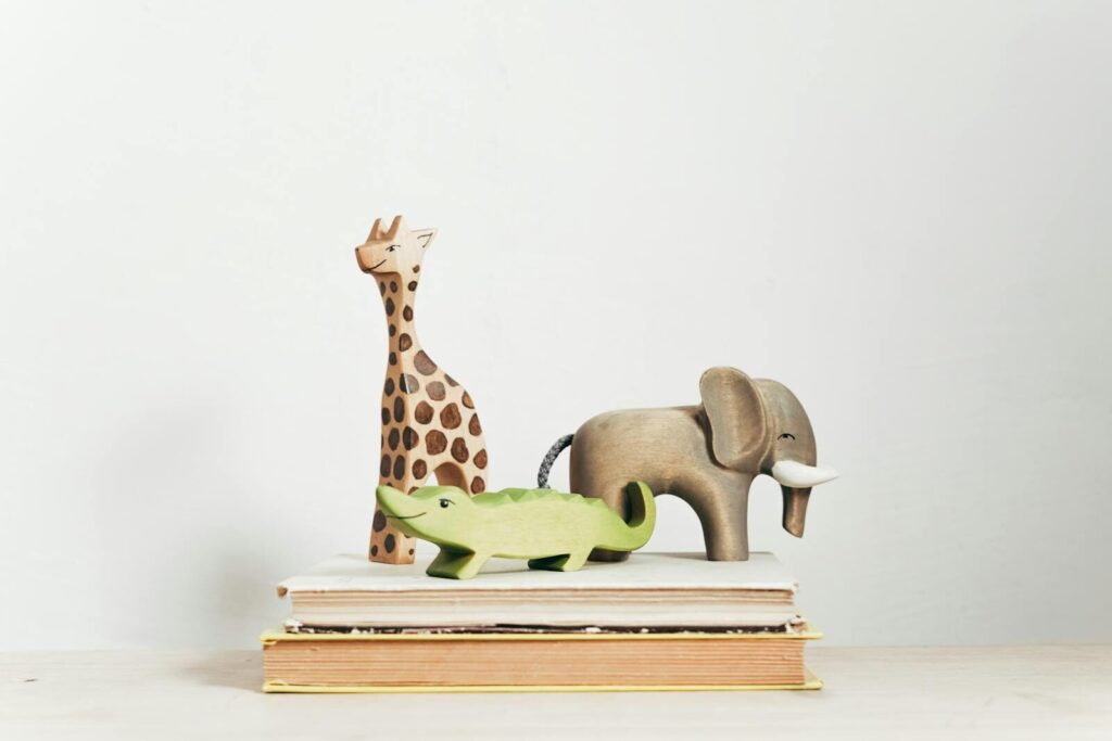 Charming display of wooden animal toys on stacked books, perfect for children's decor.