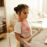 Young girl with rolling pin and flour